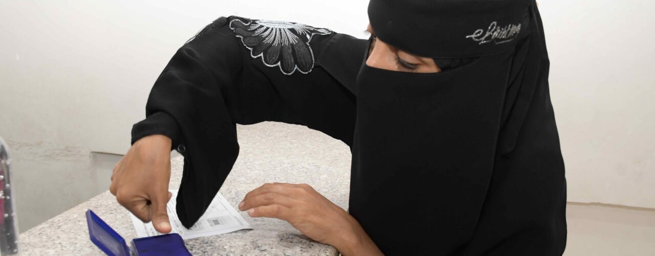 Woman puts her fingerprints in order to receive cash assistance